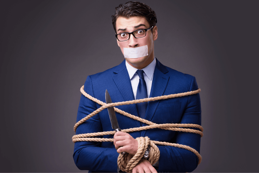 self-sabotage; man tied up in rope